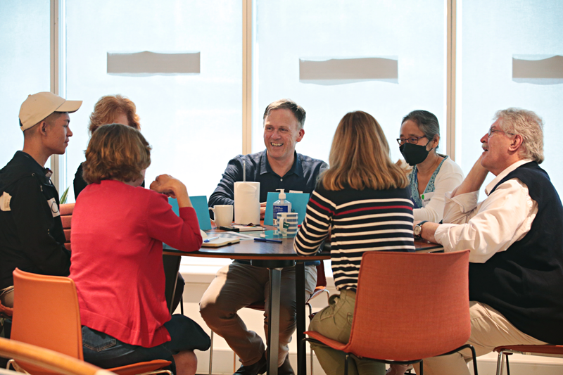 A group of people sitting around a table talking.